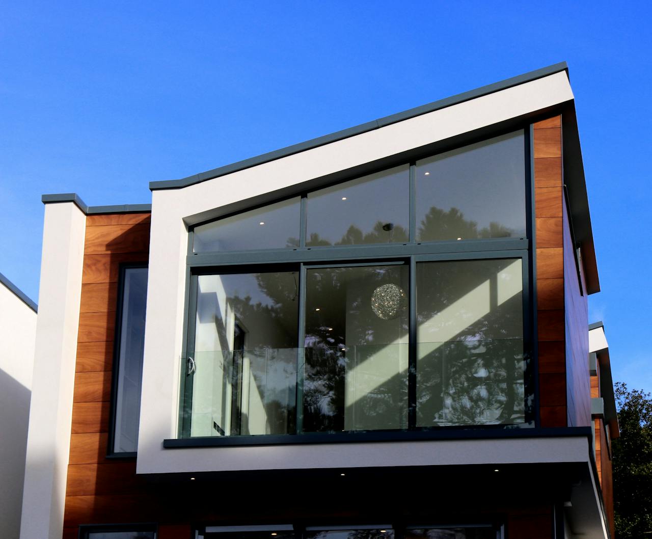 services-02 Contemporary house in Poole, UK featuring a sleek design with large glass windows and wood paneling.